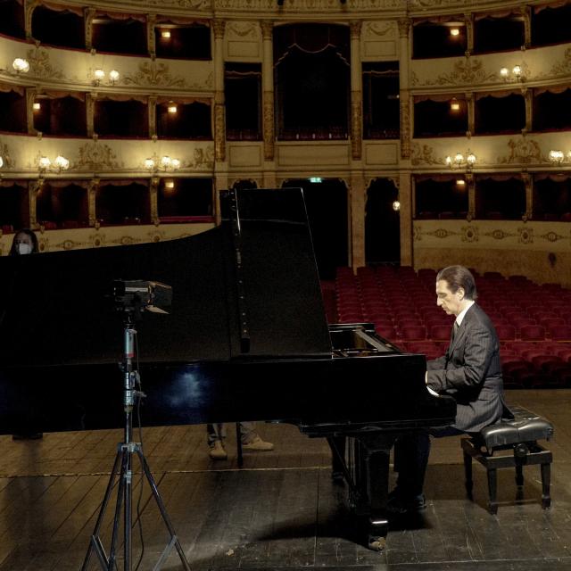 Hershey Felder as George Gershwin sits at a piano.