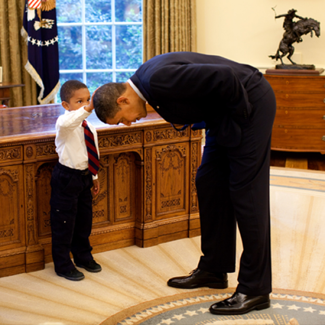Photo of President Obama and small boy touching head